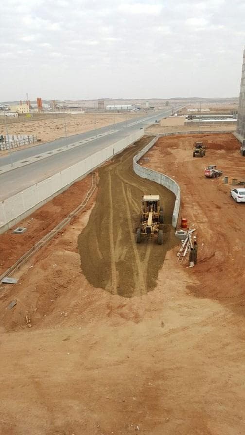 Compacted dirt road under construction beside a facility