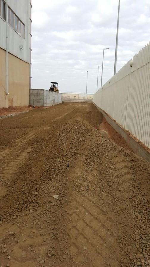 Graded earthworks alongside a perimeter fence