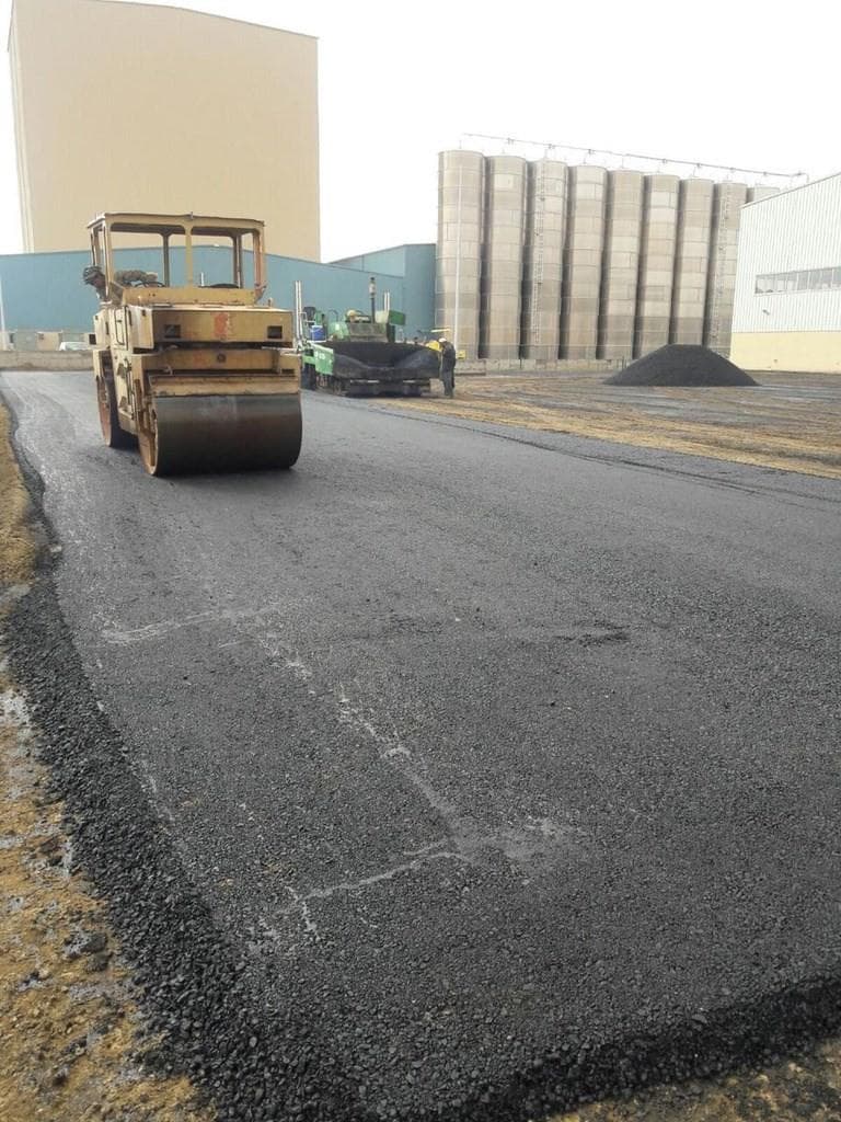Road roller compacting a freshly paved surface